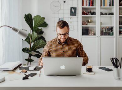 Ein Mann der vor einem MacBook sitzt. So könnte man sich einen Wirtschaftsinformatik-Student im Wirtschaftsinformatik Studium beim Lernen vorstellen.