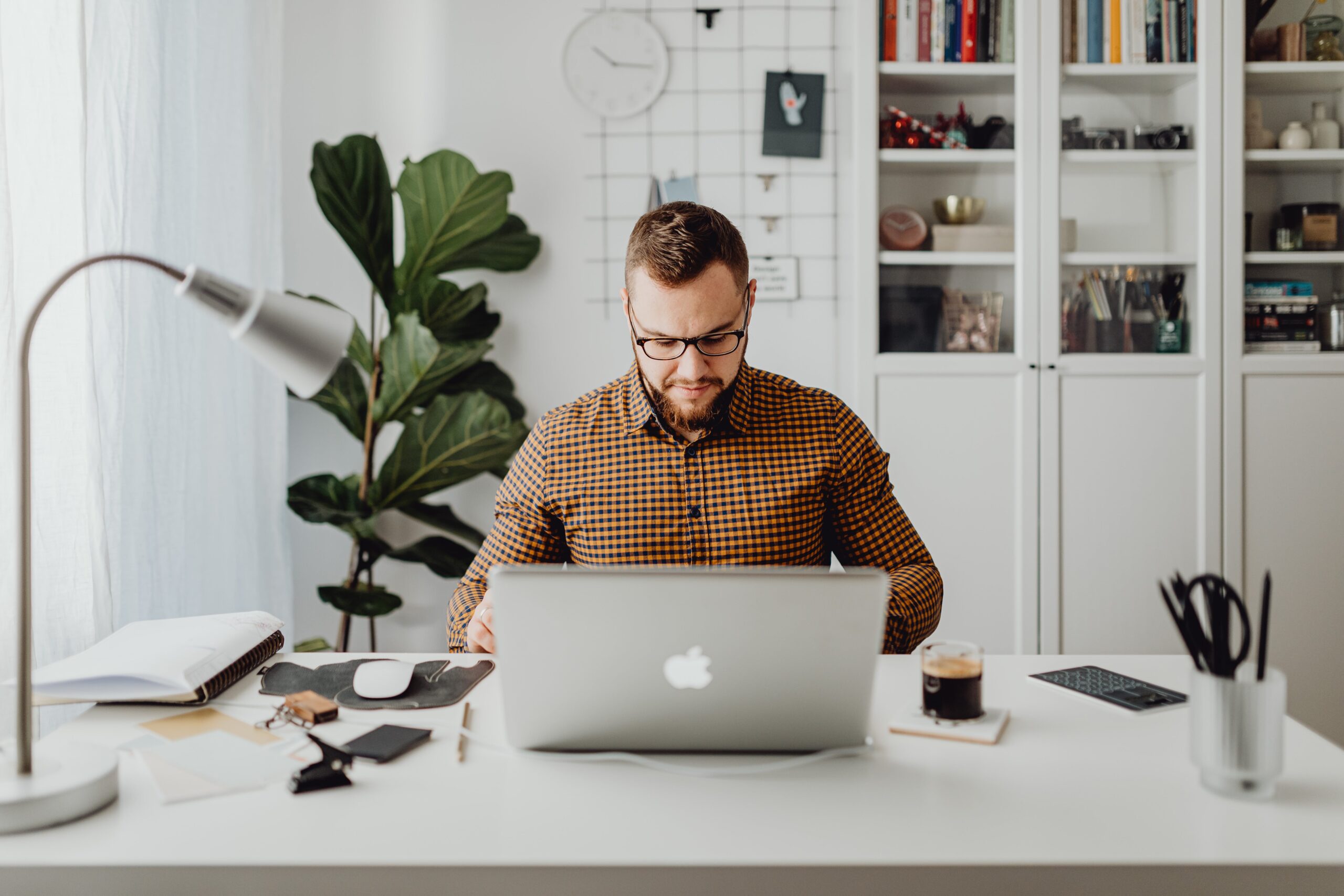 Ein Mann der vor einem MacBook sitzt. So könnte man sich einen Wirtschaftsinformatik-Student im Wirtschaftsinformatik Studium beim Lernen vorstellen.